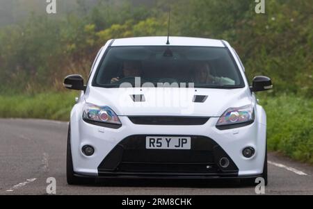 Whittlebury, Northants, UK - 26. August 2023: 2010 weißes Ford Focus RS-Auto, das an einem feuchten und nebligen Morgen auf einer englischen Landstraße fährt. Stockfoto