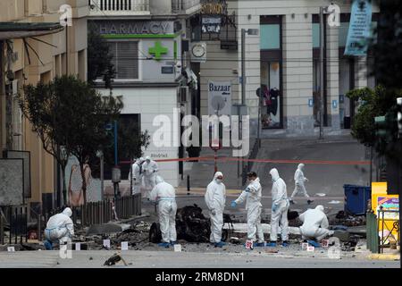 ATHEN, Polizei-Bombenbeseitigungsexperten suchen nach Beweisen in der Nähe von Überresten eines Autos nach einer Autobombenexplosion im Zentrum von Athen, Griechenland, am 10. April 2014. Eine Autobombe explodierte am frühen Donnerstag vor der griechischen Zentralbank im Zentrum von Athen und verursachte Schäden an Büros, Geschäften und Autos in der Nähe. Es wurden keine Verletzungen gemeldet. Der Vorfall ereignete sich zu einer Zeit, als Griechenland am Donnerstag zum ersten Mal seit Beginn der Krise im Jahr 2010 seine Rückkehr an die internationalen Anleihemärkte machen sollte, indem es den Anlegern fünfjährige Anleihen anbot. (Xinhua/Marios Lolos) (lyx) GRIECHENLAND-ATHEN-CAR BOMB-BLAST Stockfoto