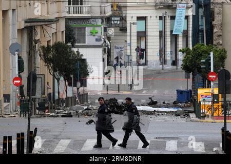 ATHEN, Polizei-Bombenbeseitigungsexperten suchen nach Beweisen in der Nähe von Überresten eines Autos nach einer Autobombenexplosion im Zentrum von Athen, Griechenland, am 10. April 2014. Eine Autobombe explodierte am frühen Donnerstag vor der griechischen Zentralbank im Zentrum von Athen und verursachte Schäden an Büros, Geschäften und Autos in der Nähe. Es wurden keine Verletzungen gemeldet. Der Vorfall ereignete sich zu einer Zeit, als Griechenland am Donnerstag zum ersten Mal seit Beginn der Krise im Jahr 2010 seine Rückkehr an die internationalen Anleihemärkte machen sollte, indem es den Anlegern fünfjährige Anleihen anbot. (Xinhua/Marios Lolos) (lyx) GRIECHENLAND-ATHEN-CAR BOMB-BLAST Stockfoto