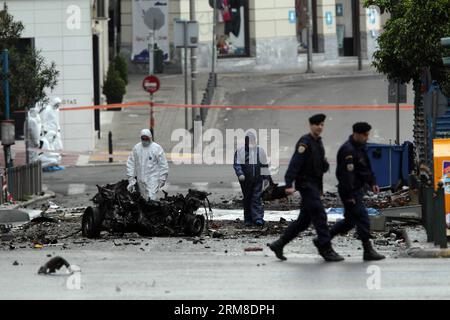 ATHEN, Polizei-Bombenbeseitigungsexperten suchen nach Beweisen in der Nähe von Überresten eines Autos nach einer Autobombenexplosion im Zentrum von Athen, Griechenland, am 10. April 2014. Eine Autobombe explodierte am frühen Donnerstag vor der griechischen Zentralbank im Zentrum von Athen und verursachte Schäden an Büros, Geschäften und Autos in der Nähe. Es wurden keine Verletzungen gemeldet. Der Vorfall ereignete sich zu einer Zeit, als Griechenland am Donnerstag zum ersten Mal seit Beginn der Krise im Jahr 2010 seine Rückkehr an die internationalen Anleihemärkte machen sollte, indem es den Anlegern fünfjährige Anleihen anbot. (Xinhua/Marios Lolos) (lyx) GRIECHENLAND-ATHEN-CAR BOMB-BLAST Stockfoto