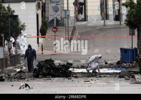 ATHEN, Polizei-Bombenbeseitigungsexperten suchen nach Beweisen in der Nähe von Überresten eines Autos nach einer Autobombenexplosion im Zentrum von Athen, Griechenland, am 10. April 2014. Eine Autobombe explodierte am frühen Donnerstag vor der griechischen Zentralbank im Zentrum von Athen und verursachte Schäden an Büros, Geschäften und Autos in der Nähe. Es wurden keine Verletzungen gemeldet. Der Vorfall ereignete sich zu einer Zeit, als Griechenland am Donnerstag zum ersten Mal seit Beginn der Krise im Jahr 2010 seine Rückkehr an die internationalen Anleihemärkte machen sollte, indem es den Anlegern fünfjährige Anleihen anbot. (Xinhua/Marios Lolos) (lyx) GRIECHENLAND-ATHEN-CAR BOMB-BLAST Stockfoto