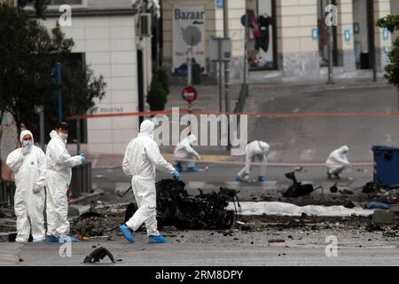 ATHEN, Polizei-Bombenbeseitigungsexperten suchen nach Beweisen in der Nähe von Überresten eines Autos nach einer Autobombenexplosion im Zentrum von Athen, Griechenland, am 10. April 2014. Eine Autobombe explodierte am frühen Donnerstag vor der griechischen Zentralbank im Zentrum von Athen und verursachte Schäden an Büros, Geschäften und Autos in der Nähe. Es wurden keine Verletzungen gemeldet. Der Vorfall ereignete sich zu einer Zeit, als Griechenland am Donnerstag zum ersten Mal seit Beginn der Krise im Jahr 2010 seine Rückkehr an die internationalen Anleihemärkte machen sollte, indem es den Anlegern fünfjährige Anleihen anbot. (Xinhua/Marios Lolos) (lyx) GRIECHENLAND-ATHEN-CAR BOMB-BLAST Stockfoto