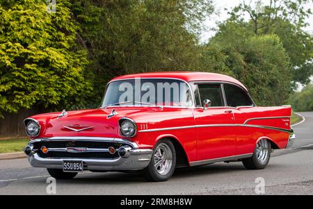 Whittlebury, Northants, UK - 26. August 2023: 1957 Red Chevrolet Bel Air American Auto, das auf einer englischen Landstraße fährt Stockfoto