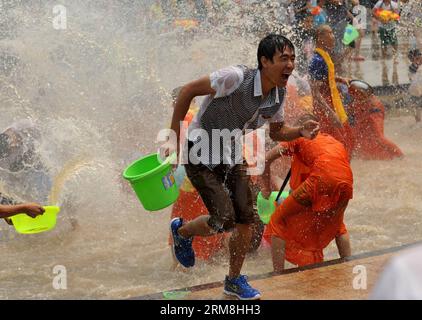 Einheimische und Touristen haben Spaß mit Wasser während des Wasserspritzerfestivals in Jinghong Stadt Dai Autonome Präfektur Xishuangbanna, Südwestchinas Provinz Yunnan, 15. April 2014. Am Dienstag, dem letzten Tag des Wasserspritzerfestivals 2014 und des Neujahrs der Dai-Ethnie 1376, spritzen sich die Menschen Wasser an, um ihre besten Grüße auszudrücken. (Xinhua/Lin Yiguang) (zwy) CHINA-XISHUANGBANNA-WATER-SPLASH FESTIVAL(CN) PUBLICATIONxNOTxINxCHN Einheimische und Touristen haben Spaß mit Wasser während des Wasserspritzens Festivals in Jinghong Stadt Dai Autonome Präfektur Xishuangbanna so Stockfoto