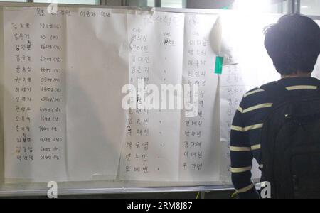 (140416) -- JINDO, 16. April 2014 (Xinhua) -- A relative of Missing People Checks Name list in Jindo, Südkorea, 16. April 2014. Ein Passagierschiff mit 462 Personen an Bord, hauptsächlich Schüler der Oberstufe, sank am Mittwochmorgen vor der Südwestküste Südkoreas in den Gewässern, wobei mindestens vier Menschen tot und 284 weitere vermisst wurden. lokale Medien berichteten unter Berufung auf das zentrale Hauptquartier für Katastrophen- und Sicherheitsmaßnahmen. (Xinhua/Yao Qilin)(ctt) S.KOREA-JINDO-SHIP SINKS PUBLICATIONxNOTxINxCHN 16. April 2014 XINHUA ein Verwandter vermisster Prominenter überprüft Namensliste in Südkorea 16. April 2014 A Passen Stockfoto