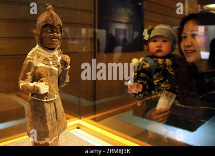 (140416) -- YANGZHOU, 16. April 2014 (Xinhua) -- Besucher sehen einen Terrakottakrieger bei einer Ausstellung, die Relikte aus dem Grab von Kaiser Yang der Sui-Dynastie (581-618) und seiner Königin zeigt, im Yangzhou Museum, Yangzhou, Provinz Jiangsu in Ostchina, 16. April 2014. Die dreimonatige Ausstellung wurde hier am Mittwoch eröffnet. Yang Guang, der zweite und letzte Monarch der kurzlebigen Sui-Dynastie, wurde während einer Meuterei 618 n. Chr. getötet, die das Ende der Dynastie markierte. (Xinhua/Zhao Jun) (hdt) CHINA-JIANGSU-YANGZHOU-KULTURELLE RELIQUIENAUSSTELLUNG (CN) PUBLICATIONxNOTxINxCHN Yang Zhou Apr Stockfoto