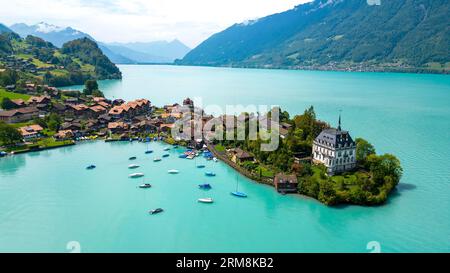 Blick aus der Vogelperspektive auf das Dorf Iseltwald am Südufer des Brienzersees, einem der atemberaubendsten türkisfarbenen Seen der Schweiz. Stockfoto