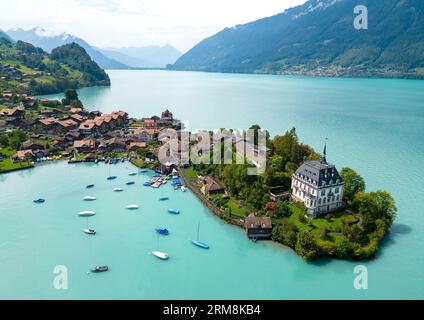 Blick aus der Vogelperspektive auf das Dorf Iseltwald am Südufer des Brienzersees, einem der atemberaubendsten türkisfarbenen Seen der Schweiz. Stockfoto