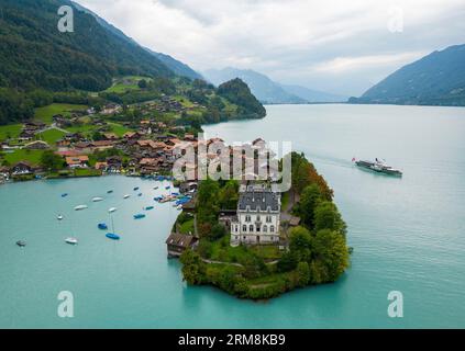 Blick aus der Vogelperspektive auf das Dorf Iseltwald am Südufer des Brienzersees, einem der atemberaubendsten türkisfarbenen Seen der Schweiz. Stockfoto