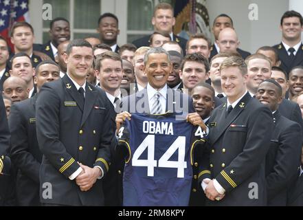 US-Präsident Barack Obama zeigt ein Geschenktrikot, als er während der Präsentation der Commander-in-Chief Trophy an das US Naval Academy Football Team im Weißen Haus in Washington am 18. April 2014 posiert. (Xinhua/Bao Dandan) US-WASHINGTON-OBAMA-NAVY-FUSSBALLTEAM PUBLICATIONxNOTxINxCHN US-Präsident Barack Obama zeigt ein Gifttrikot, während er während der PRÄSENTATION der Commander in Chief Trophy an das US Naval Academy Football Team IM Weißen Haus in Washington 18. April 2014 XINHUA Bao Dandan U.S. Washington Obama Navy Football Team PUBLICATIONxNOTxINxCHN posiert Stockfoto