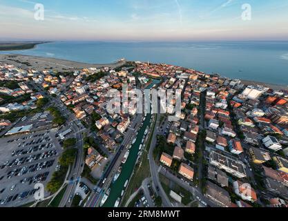 Luftaufnahme eines Caorle, der Strandstadt des Resorts in der Nähe von Venedig. Fischerboote in der Lagune bei Sonnenuntergang Stockfoto