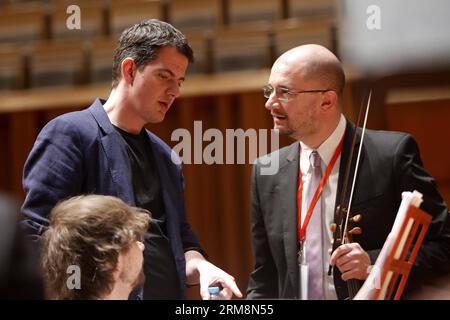 (140421) -- BEIJING, April 21, 2014 (Xinhua) -- Philippe Jaroussky (L), French countertenor singer, talks with band members at the National Grand Theater in Beijing, capital of China, April 21, 2014. The Philippe Jaroussky and Venice Baroque Orchestra Concert held on Monday was Philippe s debut in China. A countertenor is a type of classical male singing voice whose vocal range is equivalent to that of the female soprano, mezzo-soprano voice types. (Xinhua/Zhang Yuwei) (zwy) CHINA-BEIJING-PHILIPPE JAROUSSKY-DEBUT IN CHINA(CN) PUBLICATIONxNOTxINxCHN   Beijing April 21 2014 XINHUA Philippe Jarou Stock Photo