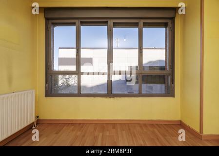 Großes ockerblaues Aluminiumfenster in einem leeren Raum Stockfoto