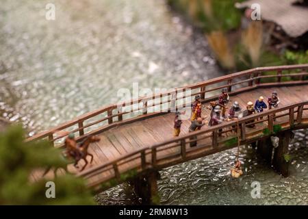 Miniatur-Diorama im Miniatur Wunderland in Hamburg, zeigt eine historische Szene mit Menschen des Mittelalters auf einer Brücke über einen Fluss Stockfoto