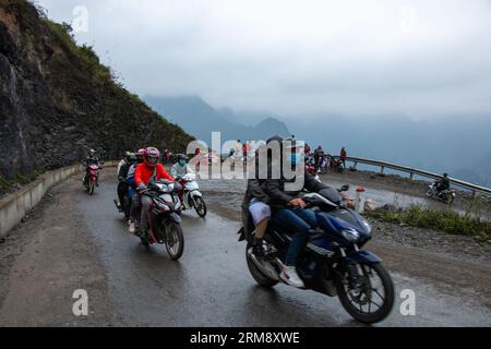Yên Minh, Vietnam - 27. Januar 2020: Gruppen von Motorradfahrern fahren durch abgelegene Berge bei kaltem und nassem Wetter entlang der Ha Giang Loop Stockfoto