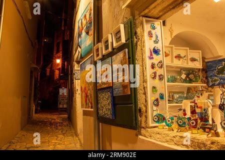 Rovinj, Kroatien - 12. Juli 2022: Souvenirladen mit schönen lokalen Kunstwerken in einer Kopfsteinpflastergasse in der atemberaubenden Altstadt von Rovinj Stockfoto