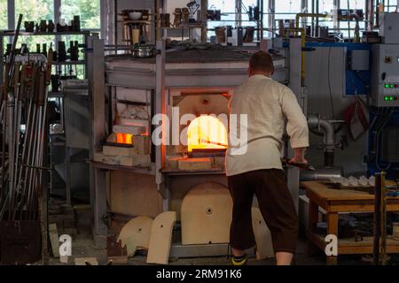 Derenburg, Deutschland - 17. August 2017: Glasbläser arbeiten an Glaskunst und erhitzen sie in einem Ofen in einer Fabrik in der Glasmanufaktur Harzkristall Stockfoto