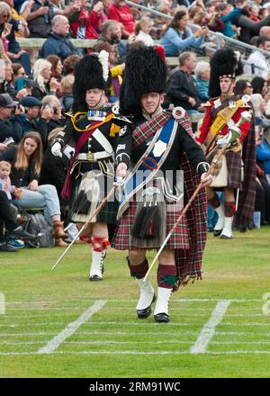 Scottish massed Pipe Bands marschieren und spielen bei The Braemar Gathering, Highland Games, Schottland. Stockfoto