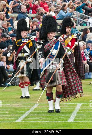 Scottish massed Pipe Bands marschieren und spielen bei The Braemar Gathering, Highland Games, Schottland. Stockfoto