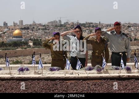 (140504) – JERUSALEM, 4. Mai 2014 (Xinhua) – israelische Soldaten grüßen, nachdem sie israelische Nationalflaggen auf den Gräbern gefallener Soldaten auf dem Militärfriedhof auf dem Ölberg in der Altstadt von Jerusalem am 4. Mai 2014 angebracht hatten. Laut jammernden Sirenen hielten am Sonntagabend Millionen von Israelis auf ihren Spuren, um einen Moment der Stille zu beobachten, als die Nation Veranstaltungen zum Gedenktag als Tribut an ihre 23.169 gefallenen Soldaten und Frauen einleitete. (Xinhua/Gil Cohen Magen) MIDEAST-JERUSALEM-ISRAEL-GEFALLENE SOLDATEN-TRAUER PUBLICATIONxNOTxINxCHN Jerusalem 4. Mai 2014 XINHUA israelische Soldaten Salute Stockfoto