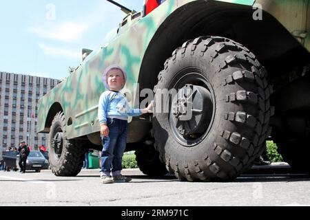 (140510) -- DONEZK, 10. Mai 2014 (Xinhua) -- Ein Junge steht bei einem gepanzerten Fahrzeug in Donezk, Ukraine, 10. Mai 2014. Ein Referendum in der ostukrainischen Region Donezk wird wie geplant am Sonntag stattfinden, sagten lokale Aktivisten, die das regionale Regierungsgebäude hier besetzt haben, am Samstag. (Xinhua/Alexander Ermochenko) UKRAINE-DONEZK-REFERENDUMSVORBEREITUNG PUBLICATIONxNOTxINxCHN Donezk 10. Mai 2014 XINHUA ein Junge steht bei der Panzerung in Donezk Ukraine 10. Mai 2014 ein Referendum in der Ostukraine S Donezk wird wie geplant AM Sonntag stattfinden, lokale Aktivisten, die die Regionalregierung B besetzt haben Stockfoto