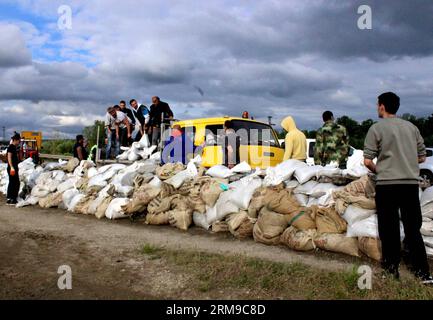 Die Menschen bauen Böschungen, indem sie Säcke mit Sand füllen und sie zu einer Mauer bauen, um am 17. Mai 2014 in Umka in Belgrad, Serbien, vor Überschwemmungen zu schützen. In einer kurzen Niederschlagspause engagierte Serbien maximale Kapazitäten, um Dämme an der Save zu sichern und Menschen in der von Überschwemmungen heimgesuchten Stadt Obrenovac zu retten. (Xinhua/Nemanja Cabric) SERBIEN-BELGRAD-ÜBERSCHWEMMUNGEN-DÄMME PUBLICATIONxNOTxINxCHN Prominente BAUEN Dämme, indem SIE Säcke mit Sand füllen und SIE zu einer Mauer bauen, um gegen Überschwemmungen in Belgrad zu schützen Serbien AM 17. Mai 2014 in einer kurzen Regenpause verpflichtete Serbien Maximum, um EM zu sichern Stockfoto