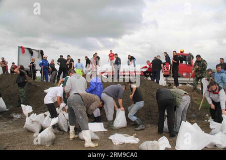 Die Menschen bauen Böschungen, indem sie Säcke mit Sand füllen und sie zu einer Mauer bauen, um am 17. Mai 2014 in Umka in Belgrad, Serbien, vor Überschwemmungen zu schützen. In einer kurzen Niederschlagspause engagierte Serbien maximale Kapazitäten, um Dämme an der Save zu sichern und Menschen in der von Überschwemmungen heimgesuchten Stadt Obrenovac zu retten. (Xinhua/Wang Hui) SERBIEN-BELGRAD-ÜBERSCHWEMMUNGEN-DÄMME PUBLICATIONxNOTxINxCHN Prominente BAUEN Dämme, indem SIE Säcke mit Sand füllen und SIE zu einer Mauer bauen, um vor Überschwemmungen in Belgrad zu schützen Serbien AM 17. Mai 2014 in kurzer Regenpause verpflichtete Serbien Maximum, um die Ufer zu sichern Stockfoto