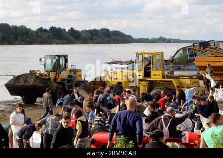 Die Menschen bauen Böschungen, indem sie Säcke mit Sand füllen und sie zu einer Mauer bauen, um am 17. Mai 2014 in Umka in Belgrad, Serbien, vor Überschwemmungen zu schützen. In einer kurzen Niederschlagspause engagierte Serbien maximale Kapazitäten, um Dämme an der Save zu sichern und Menschen in der von Überschwemmungen heimgesuchten Stadt Obrenovac zu retten. (Xinhua/Nemanja Cabric) SERBIEN-BELGRAD-ÜBERSCHWEMMUNGEN-DÄMME PUBLICATIONxNOTxINxCHN Prominente BAUEN Dämme, indem SIE Säcke mit Sand füllen und SIE zu einer Mauer bauen, um gegen Überschwemmungen in Belgrad zu schützen Serbien AM 17. Mai 2014 in einer kurzen Regenpause verpflichtete Serbien Maximum, um EM zu sichern Stockfoto