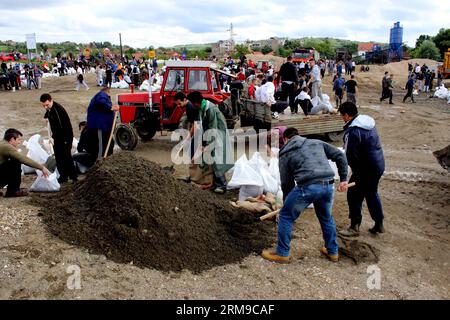 Die Menschen bauen Böschungen, indem sie Säcke mit Sand füllen und sie zu einer Mauer bauen, um am 17. Mai 2014 in Umka in Belgrad, Serbien, vor Überschwemmungen zu schützen. In einer kurzen Niederschlagspause engagierte Serbien maximale Kapazitäten, um Dämme an der Save zu sichern und Menschen in der von Überschwemmungen heimgesuchten Stadt Obrenovac zu retten. (Xinhua/Nemanja Cabric) SERBIEN-BELGRAD-ÜBERSCHWEMMUNGEN-DÄMME PUBLICATIONxNOTxINxCHN Prominente BAUEN Dämme, indem SIE Säcke mit Sand füllen und SIE zu einer Mauer bauen, um gegen Überschwemmungen in Belgrad zu schützen Serbien AM 17. Mai 2014 in einer kurzen Regenpause verpflichtete Serbien Maximum, um EM zu sichern Stockfoto