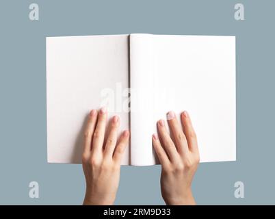 Die Hände halten das Büchermodell offen, leeres Hardcover, Hardcover-Modell. Stockfoto