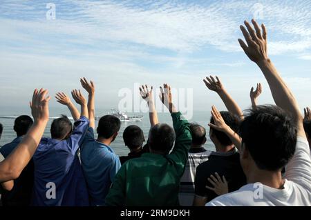 (140520) -- AN BORD von WUZHISHAN, 20. Mai 2014 (Xinhua) -- chinesische Staatsbürger an Bord des Passagierschiffes Wuzhishan winken zu einem chinesischen Marineschiff, während das Wuzhishan-Schiff nach Haikou, der Hauptstadt der südchinesischen Provinz Hainan, am 20. Mai 2014 fährt. Die erste Gruppe von gewalttätigen chinesischen Arbeitern in Vietnam traf am Dienstagmorgen im Hafen von Haikou ein. Die chinesische Regierung schickte am Sonntag vier Schiffe, um die von Aufständen betroffenen chinesischen Arbeiter in Vietnam zu evakuieren, wo schwere Gewalt gegen ausländische Unternehmen seit dem 13. Mai zwei chinesische Staatsangehörige getötet und mehr als 100 weitere verletzt hat Stockfoto