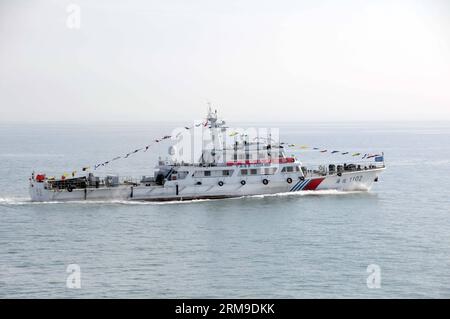 (140520) -- AN BORD von WUZHISHAN, 20. Mai 2014 (Xinhua) -- Ein Patrouillenschiff von Chiense zeigt Ein Banner Willkommen zu chinesischen Staatsangehörigen an Bord des Passagierschiffs Wuzhishan, während das Schiff von Wuzhishan nach Haikou, der Hauptstadt der südchinesischen Provinz Hainan, fährt, 20. Mai 2014. Die erste Gruppe von gewalttätigen chinesischen Arbeitern in Vietnam traf am Dienstagmorgen im Hafen von Haikou ein. Die chinesische Regierung entsandte am Sonntag vier Schiffe, um von Aufständen heimgesuchte chinesische Arbeiter in Vietnam zu evakuieren, wo schwere Gewalt gegen ausländische Unternehmen seit dem 13. Mai zwei chinesische Staatsangehörige getötet und mehr als das getan hat Stockfoto