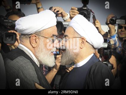 (140520) -- TEHERAN, 20. Mai 2014 (Xinhua) -- der iranische Präsident Hassan Rouhani (R) begrüßt den Leiter des iranischen Büros des obersten Führers, Mohammad Mohammadi Golpayegani (L), bevor er am 20. Mai 2014 am Flughafen Mehrabad in Teheran, Iran, nach China abreist. Rouhani verließ Teheran am Dienstagmorgen nach Shanghai, um an der Konferenz über Maßnahmen zur Förderung von Interaktion und Vertrauen in Asien (CICA) teilzunehmen, die vom 20. Bis 21. Mai in Shanghai stattfinden wird. (Xinhua/Ahmad Halabisaz) (zjy) IRAN-CHINA-ROUHANI-CICA-GIPFEL PUBLICATIONxNOTxINxCHN TEHERAN 20. Mai 2014 XINHUA iranischer Präsident Hassan Rouhani begrüßt den Leiter der IR Stockfoto