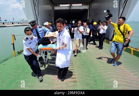 (140520) -- HAIKOU, 20. Mai 2014 (Xinhua) -- medizinische Arbeiter tragen einen verletzten chinesischen Arbeiter, während sie vom Passagierschiff Tongguling im Xiuying Hafen in Haikou, der Hauptstadt der südchinesischen Provinz Hainan, am 20. Mai 2014 aussteigen. Am Dienstag trafen gewaltgeplagte chinesische Arbeiter in Vietnam im Hafen von Haikou ein. Die chinesische Regierung entsandte am Sonntag vier Schiffe, um von Aufständen heimgesuchte chinesische Arbeiter in Vietnam zu evakuieren, wo schwere Gewalt gegen ausländische Unternehmen seit dem 13. Mai zwei chinesische Staatsangehörige getötet und mehr als 100 weitere verletzt hat. (Xinhua/Guo Cheng) (lfj) FOKUS CHINA-HAIN Stockfoto