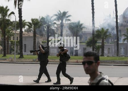 (140520) -- KAIRO, 20. Mai 2014 (Xinhua) -- Aufständische Polizeibeamte bei Zusammenstößen mit protestierenden Studenten vor dem Haupttor der Universität Kairo, 20. Mai 2014 in Kairo. Es kam zu Zusammenstößen zwischen der Polizei und Studenten der Universität Kairo, die die Muslimbruderschaft unterstützten und den ägyptischen Präsidenten Mohamed Mursi am Dienstag hier verjagten. (Xinhua/Cui Xinyu) EGYPT-CAIRO-UNIVERSITY-PROTEST-CLASH PUBLICATIONxNOTxINxCHN Kairo 20. Mai 2014 XINHUA Riot Police Guards während Zusammenstößen mit protestierenden Studenten vor dem Haupttor der Universität Kairo am 20. Mai 2014 kam es zu Zusammenstößen zwischen Riot P Stockfoto