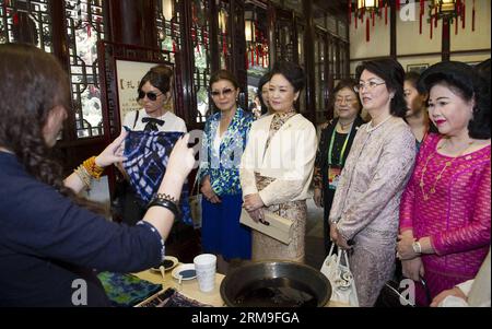 (140521) -- SHANGHAI, 21. Mai 2014 (Xinhua) -- Peng Liyuan (3. R, Front), Ehefrau des chinesischen Präsidenten Xi Jinping, Bun Rany (R), Ehefrau des kambodschanischen Premierministers Hun Sen, Mehriban Aliyeva (5. R, Front), Ehefrau des aserbaidschanischen Präsidenten Ilham Aliyev, Raisa Atambayeva, Ehefrau von Almabegyk (2. R, vorne) und Dargia Nazarbayeva, Tochter des kasachischen Präsidenten Nursultan Nasarbajew (4. R, vorne), beobachten die Demonstration von Bandhnu, einem traditionellen chinesischen Färbewerk mit verschiedenen Volksmustern, in Shanghai am 21. Mai 2014. Der vierte Gipfel der Konferenz über internationale Zusammenarbeit Stockfoto