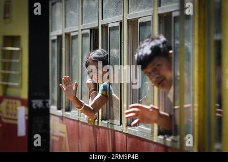 HIMACHAL PRADESH, May 28, 2013 (Xinhua) -- Passengers wave in a train on the Kalka-Shimla Railway in north India s Himachal Pradesh, May 28, 2014. The Kalka-Shimla Railway is a 762?mm narrow gauge railway in North-West India s Himachal Pradesh travelling along a mostly mountainous route from Kalka to Shimla. It is known for dramatic views of the hills and surrounding villages. The 96-km long railway was built since 1898 to provide a service to the highland town of Shimla. Three still fully operational railways, the Darjeeling Himalayan Railway in India s West Bengal, the Nilgiri Mountain Railw Stock Photo