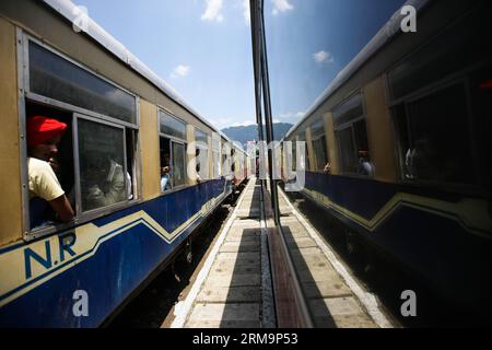 HIMACHAL PRADESH, 28. Mai 2013 (Xinhua) -- Passagiere reisen mit dem Zug auf der Kalka-Shimla-Bahn im nordindischen Himachal Pradesh, 28. Mai 2014. Die Kalka-Shimla Railway ist eine 762 mm lange Schmalspurbahn im nordwestindischen Himachal Pradesh, die auf einer überwiegend bergigen Strecke von Kalka nach Shimla verläuft. Es ist bekannt für einen dramatischen Blick auf die Hügel und die umliegenden Dörfer. Die 96 km lange Eisenbahn wurde seit 1898 gebaut, um die Hochlandstadt Shimla zu erreichen. Drei noch voll funktionsfähige Eisenbahnen, die Darjeeling Himalayan Railway in Indiens Westbengalen, die Nilgiri Mountain Railw Stockfoto