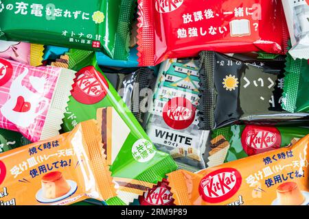 Bunte Auswahl verschiedener Gefälligkeiten japanischer Mini-zwei-Bar-Kit-Kats in einem kleinen Stapel, der von Rand zu Rand des Rahmens verläuft. Stockfoto
