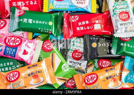 Farbenfrohe Auswahl an verschiedenen Geschmacksrichtungen der japanischen Mini-Kit Kats mit zwei Bars in einem kleinen Stapel, der von Kante zu Rand des Rahmens reicht. Stockfoto