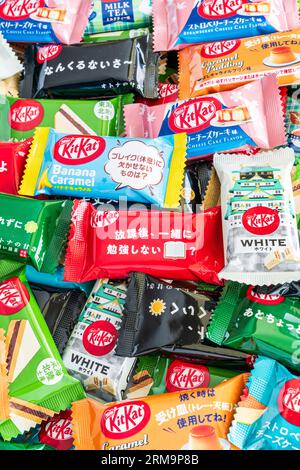 Farbenfrohe Auswahl an verschiedenen Geschmacksrichtungen der japanischen Mini-Kit Kats mit zwei Bars in einem kleinen Stapel, der von Kante zu Rand des Rahmens reicht. Stockfoto