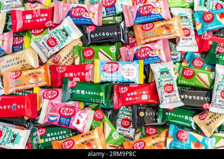 Farbenfrohe Auswahl an verschiedenen Geschmacksrichtungen der japanischen Mini-Kit Kats mit zwei Bars in einem kleinen Stapel, der von Kante zu Rand des Rahmens reicht. Stockfoto