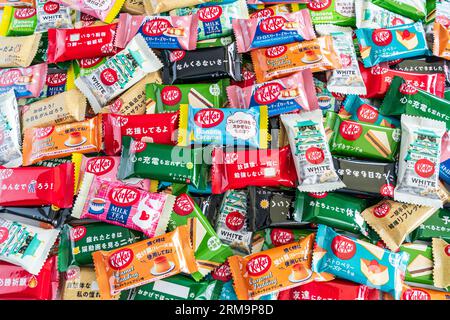 Farbenfrohe Auswahl an verschiedenen Geschmacksrichtungen der japanischen Mini-Kit Kats mit zwei Bars in einem kleinen Stapel, der von Kante zu Rand des Rahmens reicht. Stockfoto