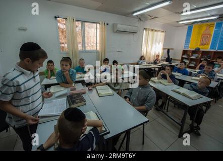 Tzviel Noyman (1. L) leitet am 29. Mai 2014 eine Klasse jüdischer Religion an der Torat Moshe Grundschule in Beit Schemesch, etwa 20 km von Jerusalem entfernt. Tzviel Noyman ist ein israelischer Ultra-orthodoxer Junge aus einer Familie mit sechs Kindern, drei Jungen und drei Mädchen. Er ist in diesem Jahr zehn Jahre alt und Schüler der dritten Klasse der Torat Moshe Grundschule, die nur für jüdische Kinder geöffnet ist. Tzviel hat acht Klassen pro Tag, darunter Hebräisch, Englisch, Mathematik und jüdische Religion, die vier Klassen pro Tag umfasst, darunter Talmud, Mischna und Gemara. Tzviel mag die Religionsklasse am besten, weil er es ist Stockfoto