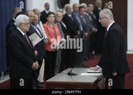 (140602) -- RAMALLAH, 2. Juni 2014 (Xinhua) - der palästinensische Premierminister Rami Al-Hamdallah (R) schwört vor Präsident Mahmoud Abbas (L-Front) während der Vereidigung der neuen Einheitsregierung in der Westbank-Stadt Ramallah am 2. Juni 2014. Der palästinensische Präsident Mahmud Abbas hat am Montag das Ende einer siebenjährigen politischen Spaltung zwischen seiner Fatah-Partei und der islamischen Hamas-Bewegung angekündigt. (Xinhua/Fadi Arouri) (zjy) MIDEAST-RAMALLAH-UNITY-GOVERNMENT PUBLICATIONxNOTxINxCHN Ramallah 2. Juni 2014 XINHUA PALÄSTINENSISCHE Premierminister Rami Al Hamdallah r SCHWÖRT vor P Stockfoto