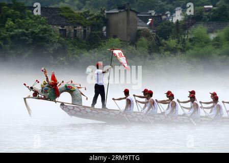 Die Teilnehmer rudern auf einem Drachenboot während eines Rennens in der Taohuatan Scenic Area, um das Dragon Boat Festival im Jingxian County in der ostchinesischen Provinz Anhui am 1. Juni 2014 zu feiern. Das Dragon Boat Festival, auch bekannt als Duanwu, wird jährlich am fünften Tag des fünften Monats des chinesischen Mondkalenders gefeiert, der in diesem Jahr am 2. Juni stattfindet. (Xinhua) (lmm) CHINA-DRAGON BOAT FESTIVAL-DUANWU-RACE (CN) PUBLICATIONxNOTxINxCHN Wettbewerber Reihen AUF einem Drachenboot während eines Rennhelden in der malerischen Gegend, um das Dragon Boat Festival im Jing Xian County Ostchina S Anhui Provinz Juni zu feiern Stockfoto
