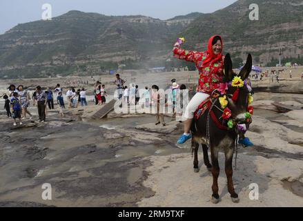 (140602) --YICHUAN, 2. Juni 2014 (Xinhua) -- Eine Frau posiert für ein Foto in der Nähe des Hukou-Wasserfalls des Gelben Flusses im Yichuan County, Provinz Shaanxi im Nordwesten Chinas, 2. Juni 2014. (Xinhua/Liu Xiao) (yxb) CHINA-HUKOU-WASSERFALL-LANDSCHAFT (CN) PUBLICATIONxNOTxINxCHN Yichuan 2. Juni 2014 XINHUA eine Frau posiert für ein Foto in der Nähe des Hukou-Wasserfalls des Gelben Flusses im Nordwesten Chinas S Shaanxi-Provinz Juni 2 2014 XINHUA Liu XiCHIxCN-Wasserfall China Stockfoto