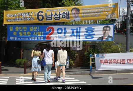 (140604) -- SEOUL, 4. Juni 2014 (Xinhua) -- People Walk Pass Wahlplakate in Seoul, Südkorea, 4. Juni 2014. Die Südkoreaner werden insgesamt 3.952 Beamte wählen, darunter 17 Bürgermeister, Provinzgouverneure und Superintendenten, 226 Leiter von Verwaltungseinheiten auf niedriger Ebene sowie etwa 3.700 Gemeindemitglieder. Die Abstimmung begann von 6.00 Uhr an 13.665 Wahllokalen landesweit und ging nach Angaben der Nationalen Wahlkommission (NEC) bis 18.00 Uhr weiter. (Xinhua/Yao Qilin)(ctt) SÜDKOREA-SEOUL-WAHLEN PUBLICATIONxNOTxINxCHN Seoul 4. Juni 2014 XINHUA Prominrities Walk Passport Stockfoto