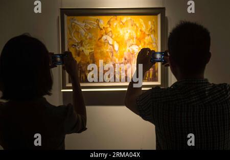 Two visitors take photos of an oil painting at the Contemporary Central and Eastern Europe (CEE) Fine Art Exhibition at the Ningbo Museum of Art in Ningbo, east China s Zhejiang Province, June 7, 2014. Opening on Saturday as part of the 2014 China Ningbo-CEEC Economic & Cultural Exchange Week, the five-day exhibition displays paintings from 11 CEE countries including Romania, Hungary and the Czech Republic. (Xinhua/Han Chuanhao) (lmm) CHINA-ZHEJIANG-NINGBO-CENTRAL & EASTERN EUROPE-FINE ART-EXHIBITION (CN) PUBLICATIONxNOTxINxCHN   Two Visitors Take Photos of to Oil Painting AT The Contemporary Stockfoto