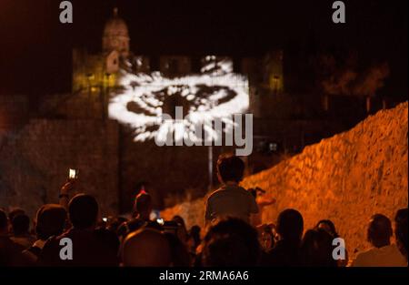 A child looks at an audiovisual show projected on the wall of Armenian Patriarchate St. at Armenian Quarter in the Old City of Jerusalem, on June 19, 2014. The sixth Jerusalem Festival of Light is closed on Thursday after a nine-day presentation of illumination works, light shows, three-dimensional artistic displays and huge video projections on Old City buildings and on the Old City walls through four guided routes. (Xinhua/Li Rui) MIDEAST-JERUSALEM-OLD CITY-THE 6TH JERUSALEM FESTIVAL OF LIGHT PUBLICATIONxNOTxINxCHN   a Child Looks AT to  Show projected ON The Wall of  Patriarchate St AT  Qua Stock Photo